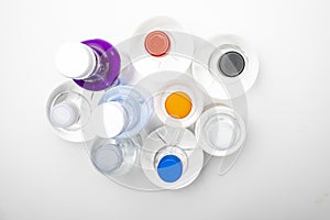 Background of transparent spherical water bottles with colored caps. Top view