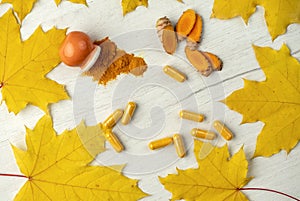 Background with turmeric in different shapes Capsules and powder in a mini orange pot and root cut into pieces