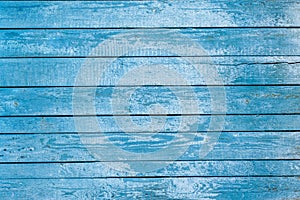 The background is turquoise and the color of old painted wooden boards. Wooden background blue with peeling paint from long boards