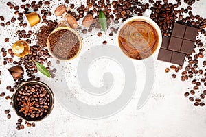 Background of various coffee , dark roasted coffee beans , ground and capsules with scoops setup on white concrete background with