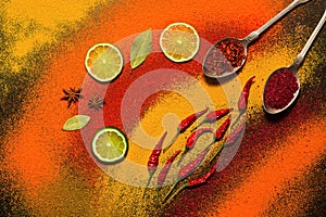 Background of various spices, red, orange, yellow. Paprika, turmeric, anise, bay leaf, chilli pepper, lime, saffron. Assorted spic