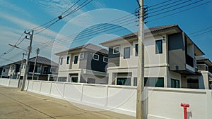 The background wall is lined with housing estates and electric poles run along the sides of the wall.