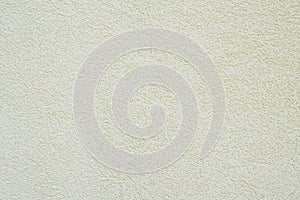Off-white or pale yellow roughcast plaster texture background wall