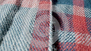 Background from a warm woolen plaid shirt with red buttons in macro. Structure of the garment, textile material, soft