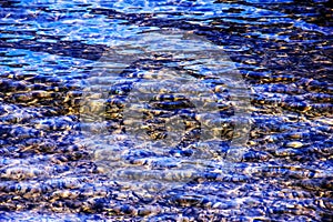 Background of the water of Lake Traunsee in the coastal area. Colorful texture of stones under water