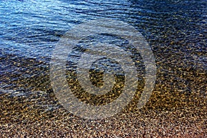 Background of the water of Lake Traunsee in the coastal area. Colorful texture of stones under water