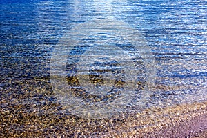 Background of the water of Lake Traunsee in the coastal area. Colorful texture of stones under water