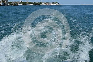 Background with wave and foam, trace on the surface of the water behind the fast moving ship