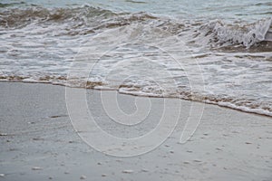 Background of waves beating on a sandy beach in stormy weather