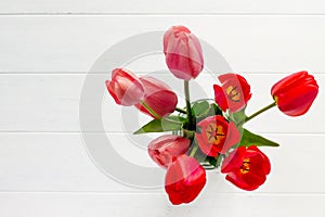 Background wedding or Valentine`s Day. Red and pink tulips bouquet on a wooden table. The apartment was lying.