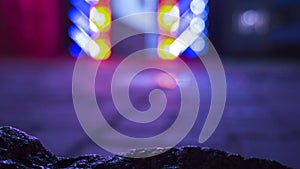 Background of wet asphalt with neon light. Blurred background, night lights of a big city, reflection, puddles.