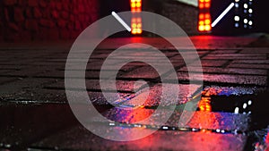 Background of wet asphalt with neon light. Blurred background, night lights of a big city, reflection, puddles.