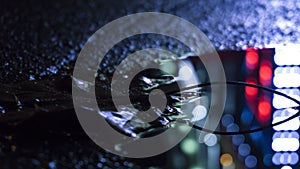 Background of wet asphalt with neon light. Blurred background, night lights of a big city, reflection, puddles.