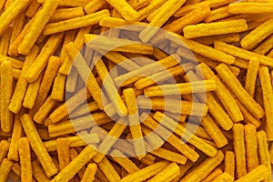 Background of wheat and corn chips with a taste of cheese in the form of sticks