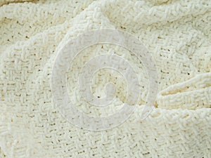 Background of white knitted plaid. Creases on soft surfaces