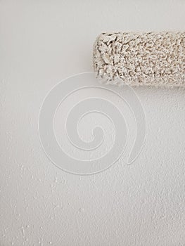 Painting a textured white wall with white paint roller