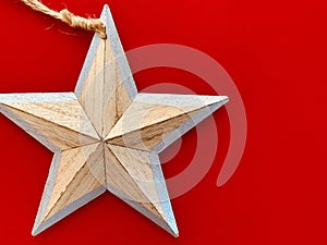 Background with wooden Christmas decorations star on red background. Space for text