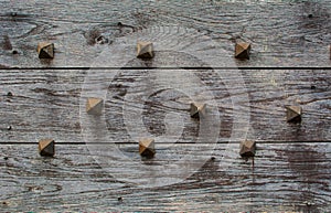 Background of wooden grey planks with metal spikes