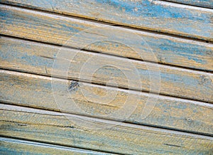 Background of wooden slats of planks located on a diagonal of yellow and blue color aged wood