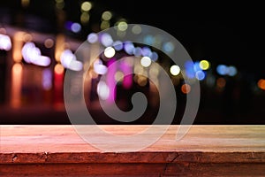 Background of wooden table in front of abstract blurred restaurant lights