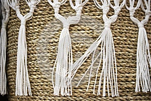 Background of woven basket with macrame trim and tassels - selective focus