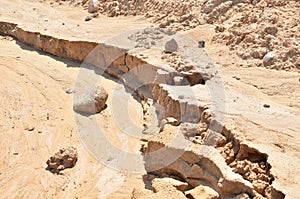 Background of yellow sand with small stones after rain. Soil erosion after heavy rainfall and precipitation. Texture of scattered