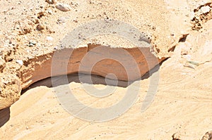 Background of yellow sand with small stones after rain. Soil erosion after heavy rainfall and precipitation. Texture of scattered