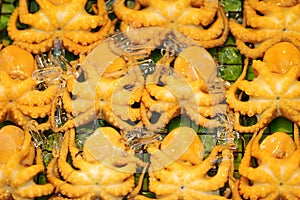 Background of yellow squids on green banana leaf