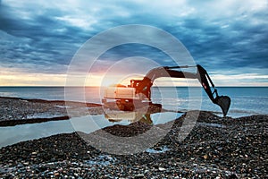 Backhoe or digger working with bucket at industrial earth excavation site