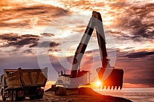 Backhoe or digger working with bucket at industrial earth excavation site