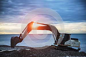 Backhoe or digger working with bucket at industrial earth excavation site