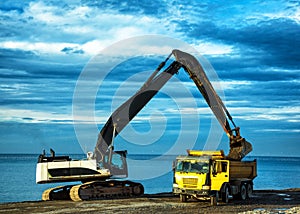 Backhoe or digger working with bucket at industrial earth excavation site