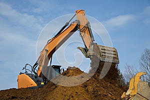 backhoe digging hydraulic shovel on construction site earth mover excavator dumping earth