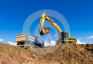 Backhoe digging and trucks.