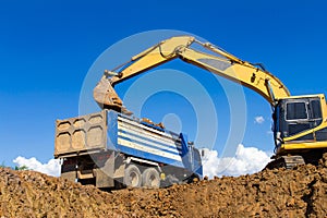 Backhoe digging and trucks.