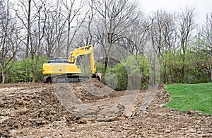 Backhoe Excavating and Reshaping Landscape