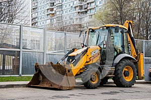 Widespread model of universal backhoe loader of JCB Company Great Britain of recognizable yellow colour.