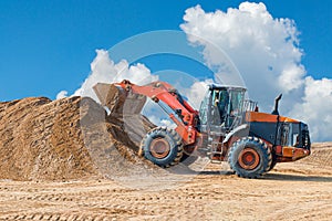 Backhoe loader or bulldozer - excavator with clipping path on a background with blue sky and clouds. work on construction site or