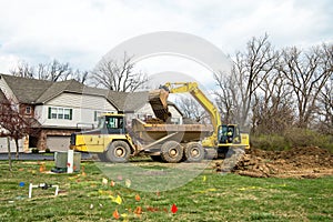 Backhoe Loading Excavated Soil into Truck