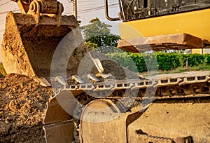 Backhoe parked at construction site after digging soil. Closeup bucket of bulldozer. Digger after work. Earth moving machine at