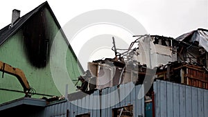 Backhoe picking up some pieces from the roof