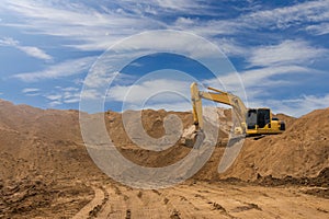 Backhoe on the sand against the sky.