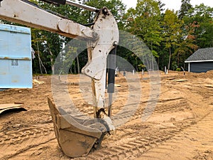 Backhoe scoop shovel attachment on dirt at a new home construction site