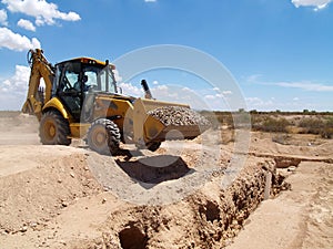 Backhoe Shoveling Gravel