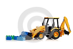 Backhoe tractor with brick toys, white background