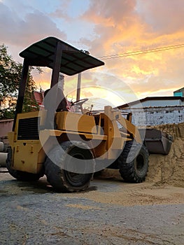 The backhoe is used for loading rocks, soil or sand in construction or agriculture work. Taken it in sunset time.