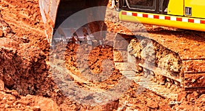 Backhoe working by digging soil at construction site. Bucket of backhoe digging soil. Crawler excavator digging on dirt.