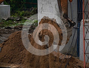 Backhoe working by digging soil at construction site. Bucket teeth of backhoe digging sand. Crawler excavator digging on soil.