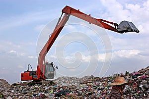 Backhoe working on garbage dump at landfill. People Working at a