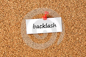 Backlash. Word written on a piece of paper, cork board background